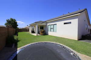 Rear view of property with a yard and a patio