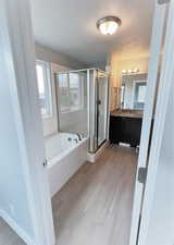 Bathroom featuring vanity, shower with separate bathtub, and a textured ceiling