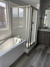 Bathroom featuring vanity, independent shower and bath, and hardwood / wood-style floors