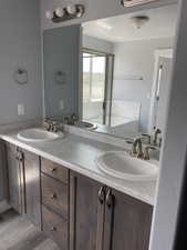 Bathroom with vanity, a bath, hardwood / wood-style flooring, and a textured ceiling
