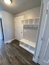 Mudroom with dark hardwood / wood-style flooring and a textured ceiling