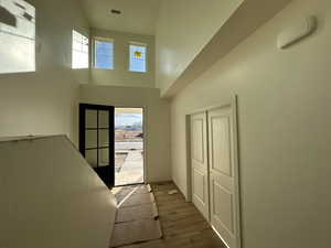 Interior space featuring hardwood / wood-style floors, a healthy amount of sunlight, a towering ceiling, and french doors