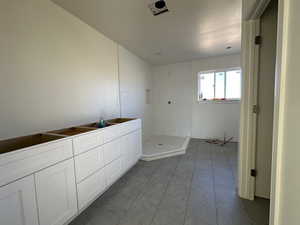 Bathroom featuring tile patterned floors, a textured ceiling, and tiled shower