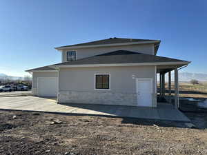 Rear view of property with a mountain view, a patio, and a garage