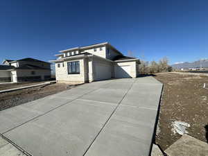 View of side of property with a mountain view and a garage