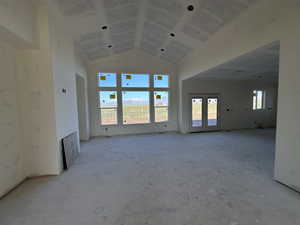 Unfurnished living room featuring vaulted ceiling