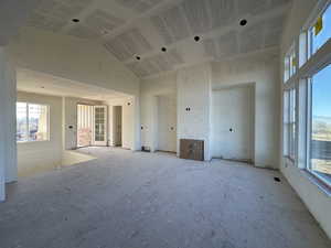 Unfurnished room with high vaulted ceiling