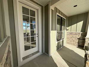 Doorway to property featuring covered porch