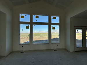 Empty room with a mountain view and lofted ceiling