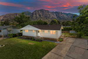 Ranch-style house featuring a storage shed, a mountain view, and a lawn