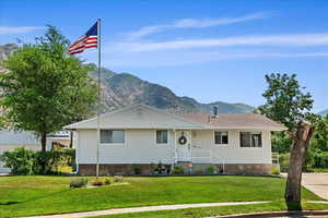 Ranch-style house with a mountain view and a front lawn