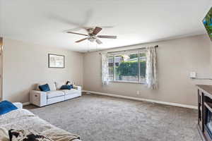 Carpeted living room with ceiling fan