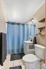 Bathroom featuring toilet, vanity, and tile patterned floors