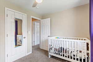 Bed 2 Carpeted bedroom with ceiling fan, a nursery area, and a closet