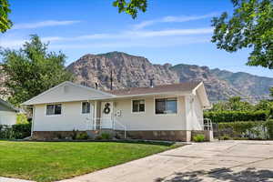 Ranch-style house featuring a front lawn and a mountain view