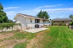 Back of property featuring a patio and a lawn