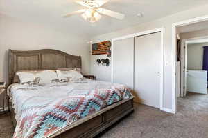 Master Carpeted bedroom with ceiling fan and a closet