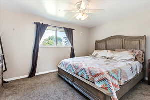 Master Carpeted bedroom with ceiling fan