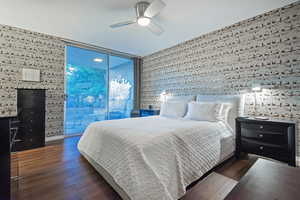 Bedroom with ceiling fan, dark hardwood / wood-style flooring, access to outside, and floor to ceiling windows