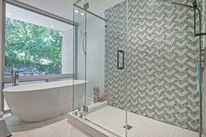 Bathroom featuring ceiling fan, an enclosed shower, and tile patterned flooring