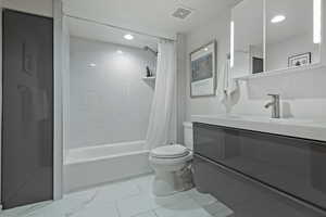 Full bathroom featuring shower / bath combination with curtain, toilet, tile patterned floors, and vanity