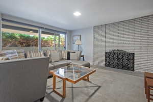 Carpeted living room featuring a brick fireplace