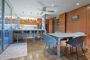 Tiled dining space with ceiling fan and sink