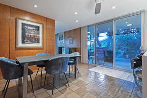 Dining room with ceiling fan, tile patterned floors, and floor to ceiling windows