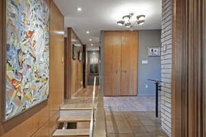 Hall with an inviting chandelier and wood-type flooring