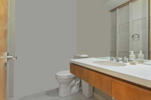 Bathroom with toilet, vanity, and tile patterned floors