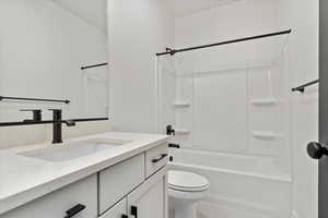 Full bathroom with vanity, shower / bathtub combination, and toilet