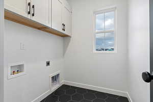 Washroom featuring washer hookup, dark tile patterned floors, cabinets, and hookup for an electric dryer