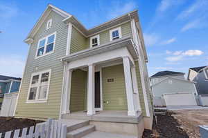 View of front of property with a porch and a garage