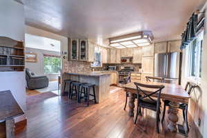 Dining area with light hardwood / wood-style floors and a textured ceiling