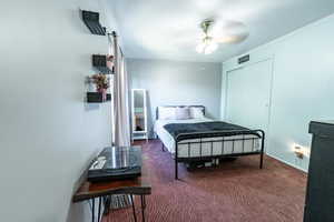 Bedroom with ceiling fan, carpet, and a closet