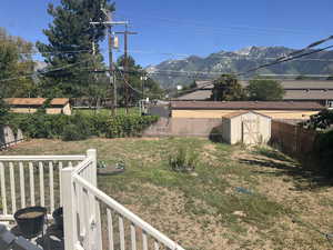 View of yard with a mountain view and a storage shed