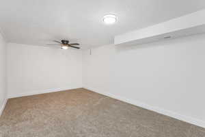 Carpeted empty room featuring ceiling fan