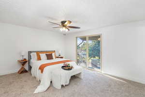 Carpeted bedroom with ceiling fan and access to exterior