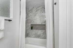 Bathroom with shower / bath combination with curtain