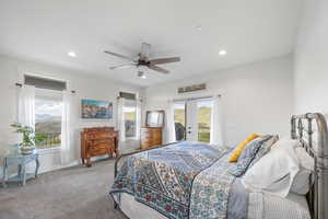 Primary bedroom with ceiling fan, access to outside covered patio with fire pit and hot tub, and french doors