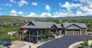 View of front of house featuring a trampoline, a garage, and a mountain view