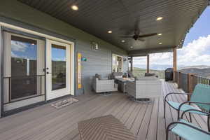 Wooden deck with ceiling fan, an outdoor hangout area, and a mountain view