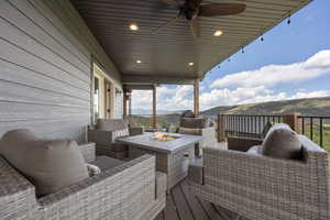 Deck featuring ceiling fan and an outdoor living space with a fire pit