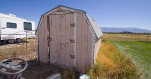 View of outdoor structure with a mountain view and a yard