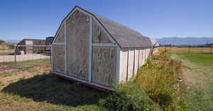 View of outbuilding with a lawn and a mountain view