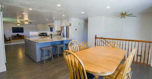 Dining space featuring a textured ceiling, ceiling fan, and dark hardwood / wood-style floors