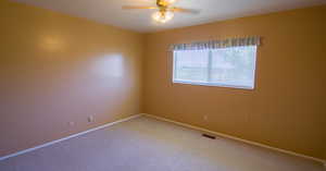 Empty room featuring ceiling fan, carpet flooring, and a textured ceiling