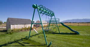 View of play area with a mountain view and a yard