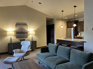 Living area with baseboards, carpet flooring, lofted ceiling, and recessed lighting
