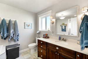 Primary bathroom with tile patterned flooring, vanity, and toilet